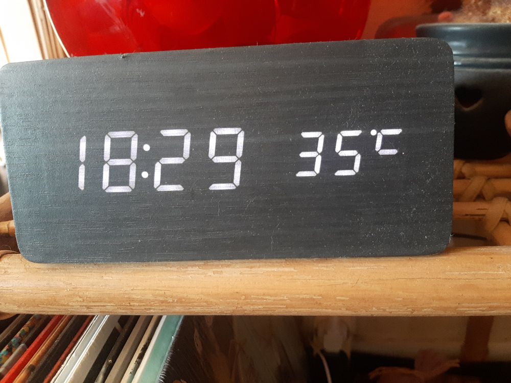 Horloge thermomètre de mon salon, indiquant 18h29, 35 degrés 