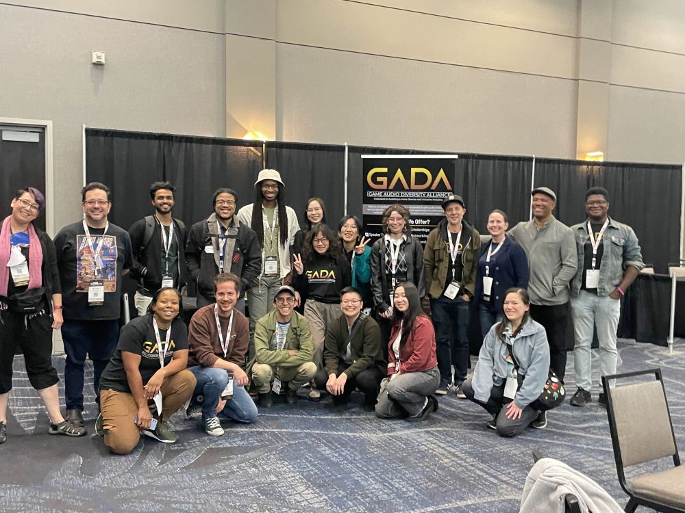 GADA scholars, volunteers, and community members stand in front of the GADA booth at GameSoundCon.