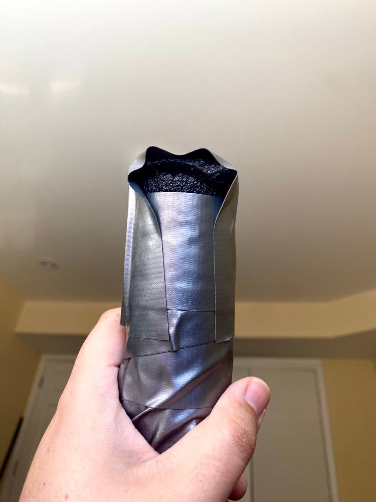 Anonsee shows the bottom of the practice shillelagh with the foam cap and one piece of tape holding it down so it’s still visible from the side