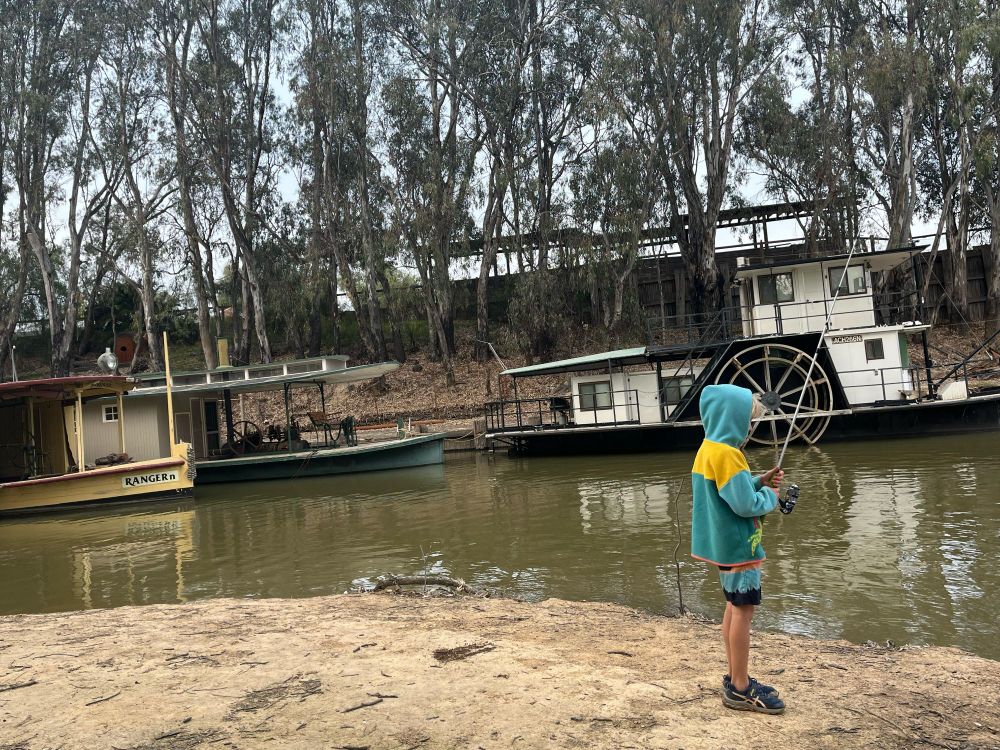 Child with hoodie on having a final fish.