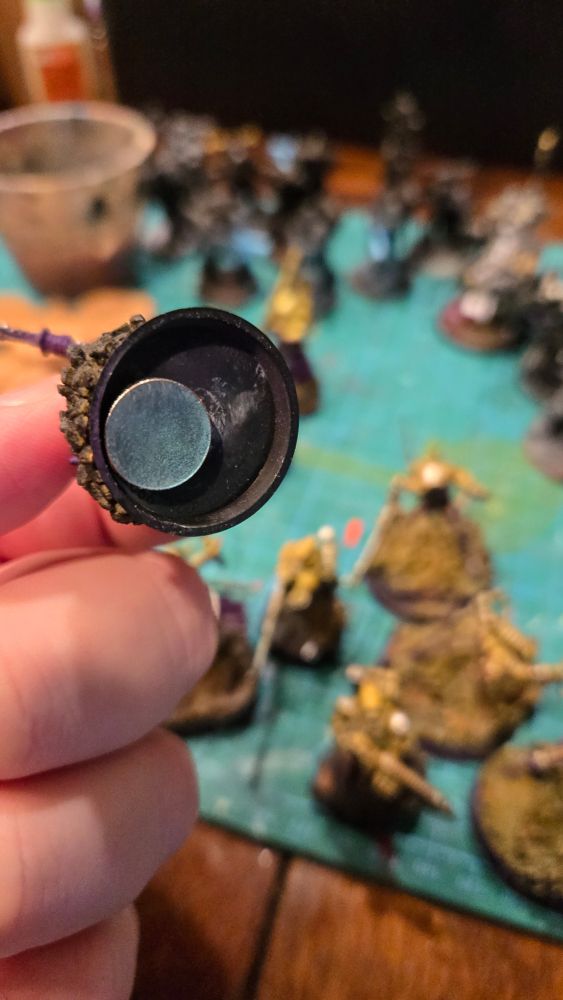 A round magnet glued to the underside of a base. 