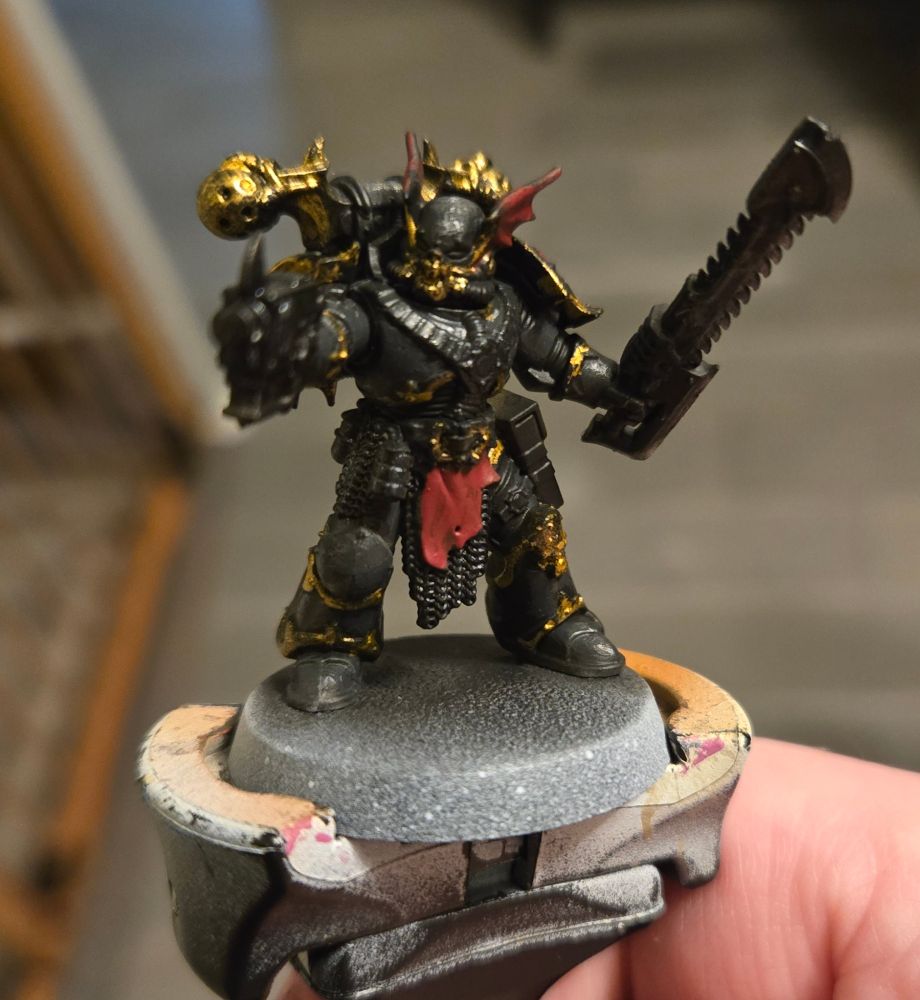 A basecoated night lord in midnight blue armor with brass trim and red accents. 