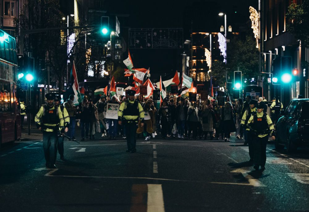 Protesters approach on the road with PSNI officers leading in front of them.