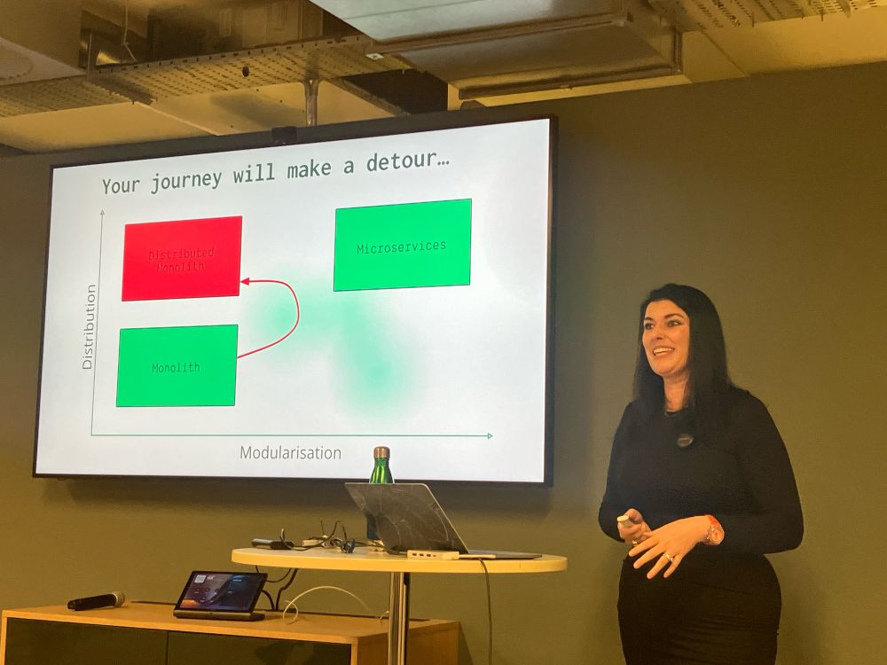 Layla Porter presenting a slide showing… lines and rectangles. Like all software architecture diagrams.