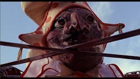 Still image. A masked Edward Woodward enjoys some pagan sword dancing. 