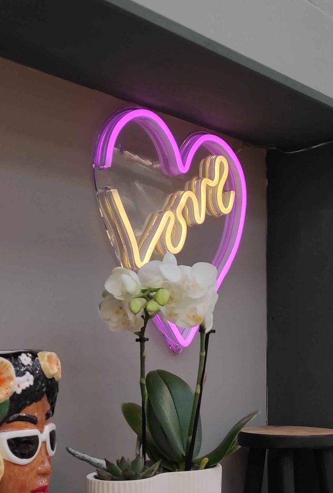 Neon sign of a heart with writing of "Love" in the middle that looks suspiciously similar to "vore"