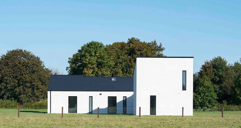 Photo shows a new farmhouse in a countryside setting, built to the nearly zero energy building standard