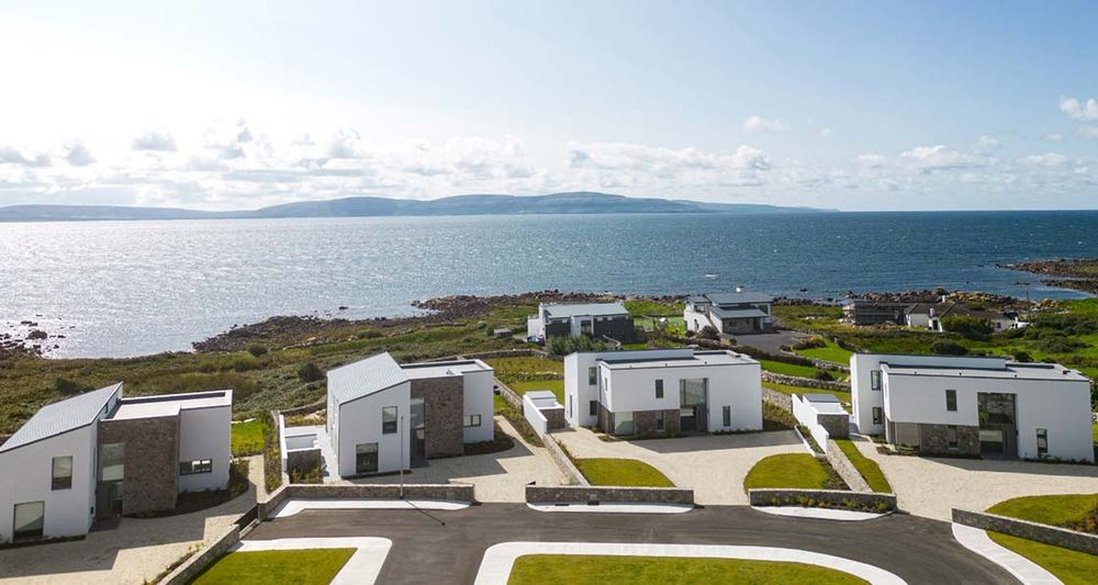 Photograph shows a passive house scheme beside the sea in Connemara, Ireland