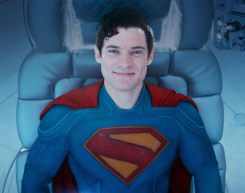 David Corenswet's Superman laying down on his chair at the end of SUPERMAN (2025) smiling at the camera