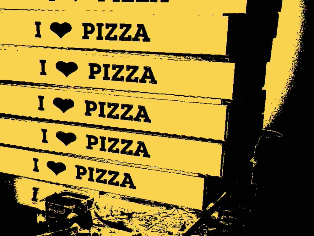 A stack of pizza boxes that say I ❤️ Pizza
