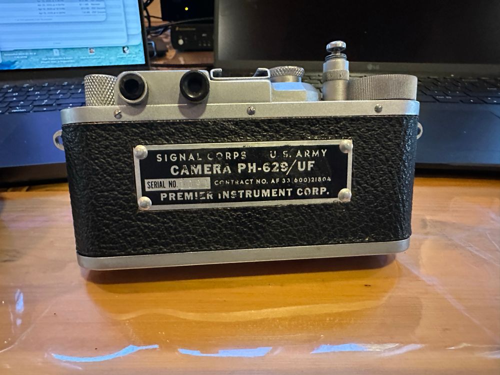 The back of the camera with a plate that reads Signal Corps U. S. Army Camera PH-629/UF Serial No. 1091 Contract No. AF 33 600) 21804 Premier Instrument Corp.