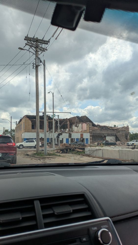 A two-story brick building with the second floor almost entirely collapsed