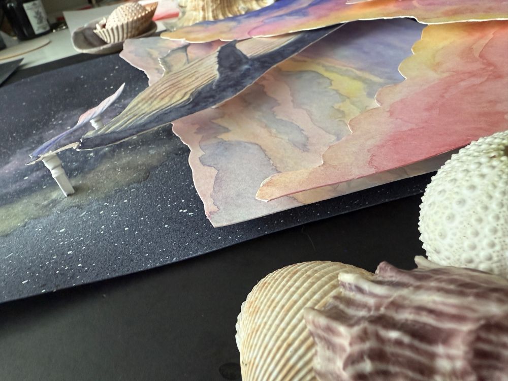 Angled photo of the painting to see the multiple hand cut layers of painted paper.