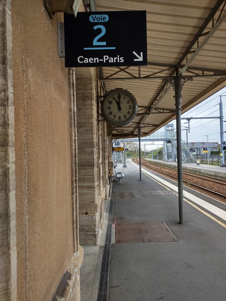 Large clock on train platform, hands showing 11:00