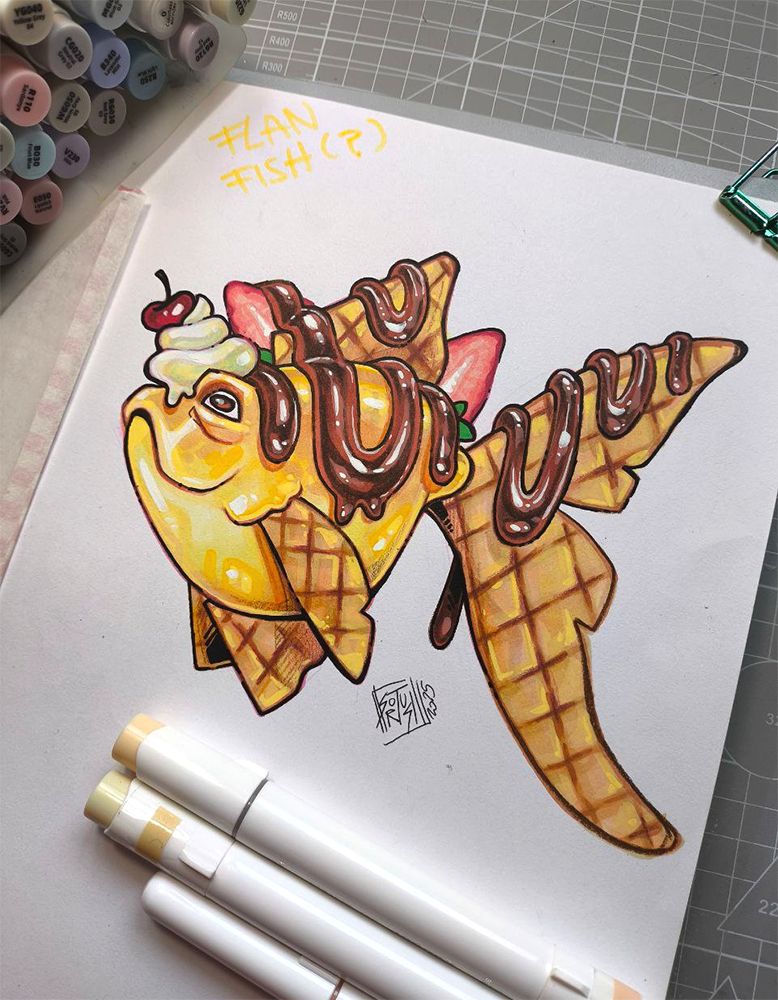 a sketchbook page with a fish painted in markers, the fish is yellow with caramel and waffle fins
