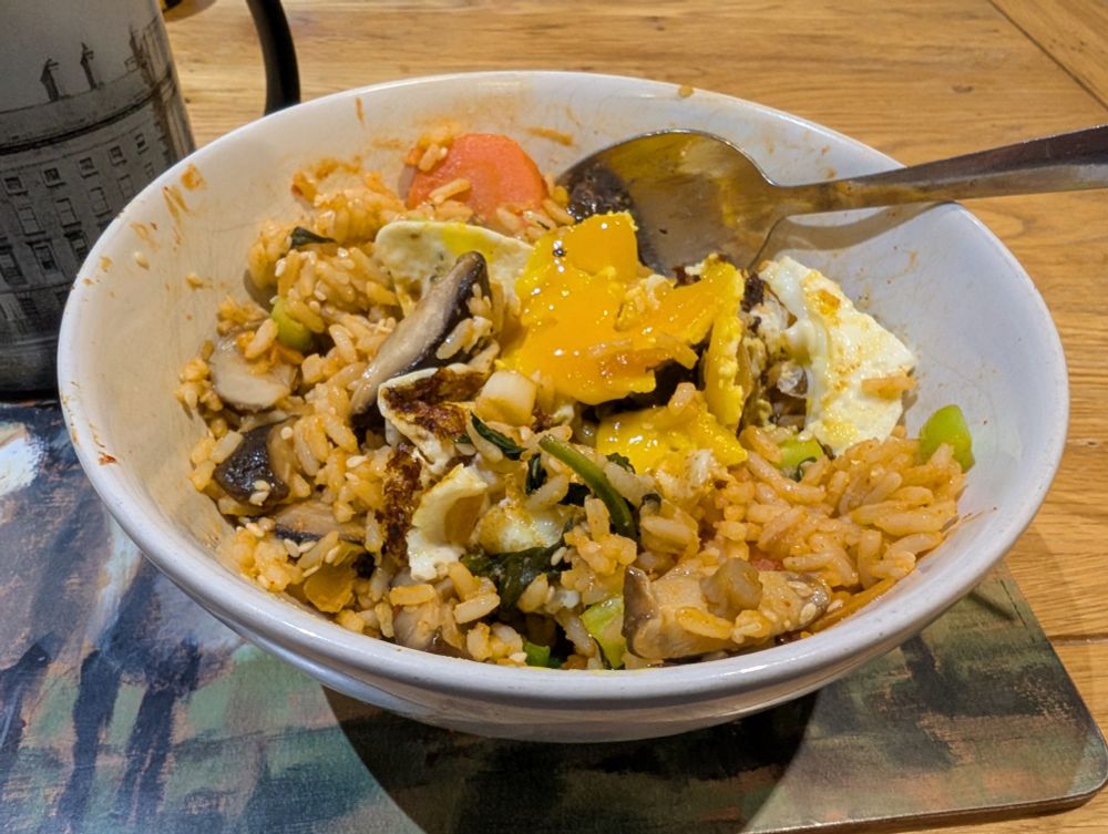 Kimchi rice with carrots, mushrooms, spinach and a fried egg.