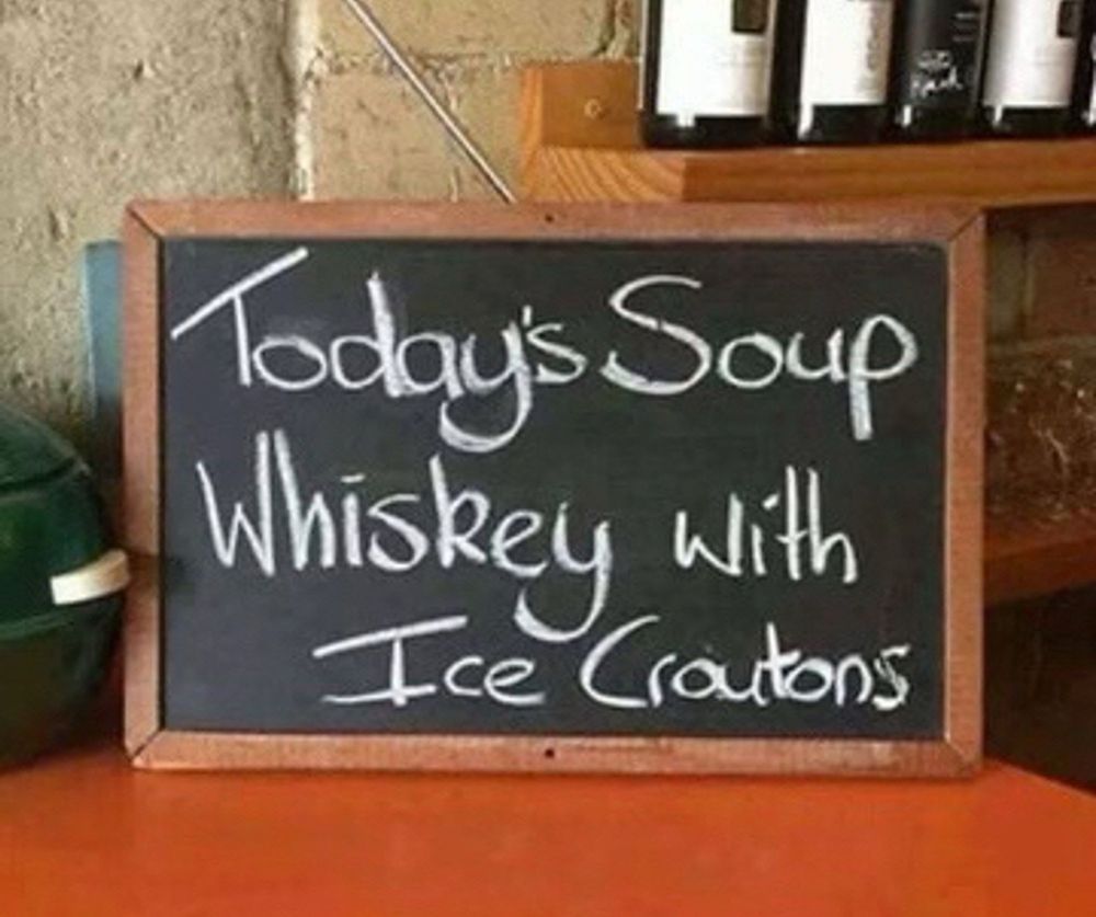A chalk board written sign that says: Today’s Soup 
Whiskey with Ice Croutons 