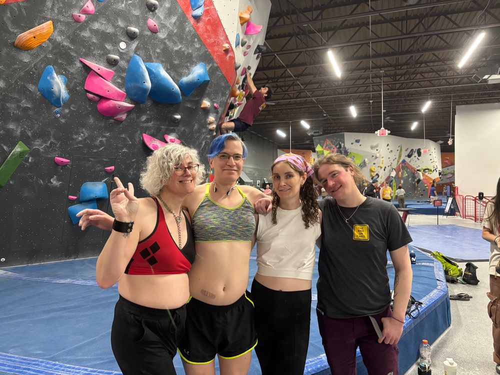 a group of 4 people posing for a picture at the climbing gym 