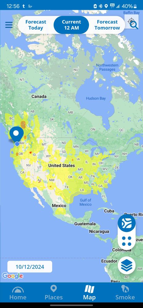 Screenshot of most of North America, Central America, and just the tip of South America from the APP AirNow, from the EPA air quality map. Yellow coloring covering the center of the USA and spreading in all directions. The yellow represents smoke and other air pollution. Red and orange dots can be seen spread across mostly the west coast, including into Canada. This was taken 12:56 am on 10/12/2024