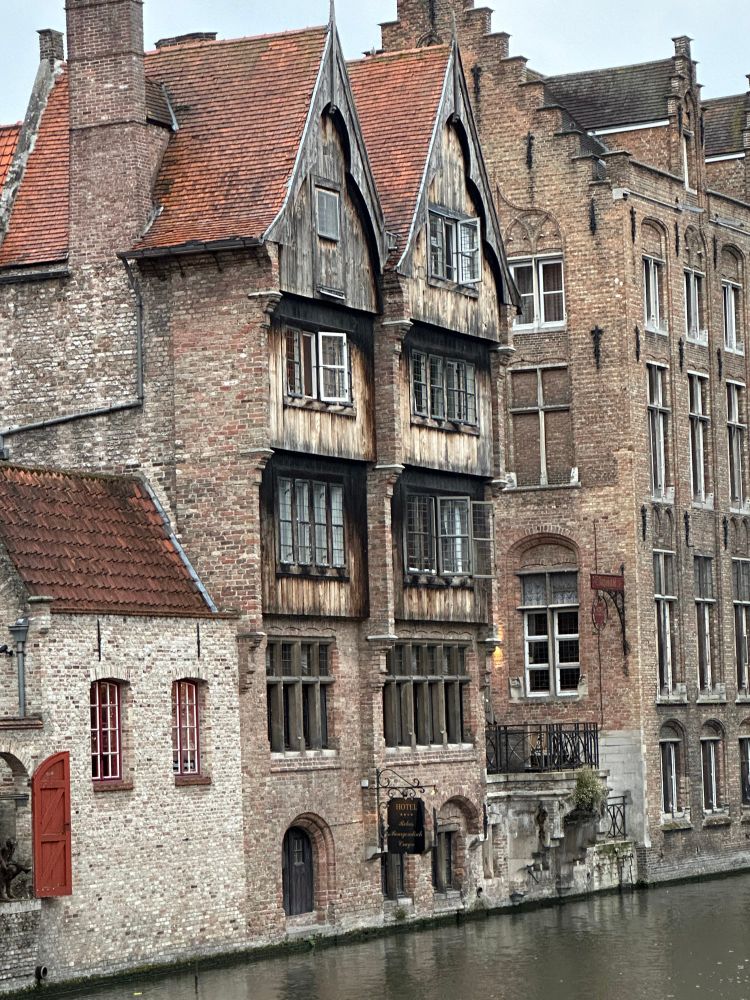 The rear façade of the hotel from “In Bruges”, a medieval building with windows above a canal