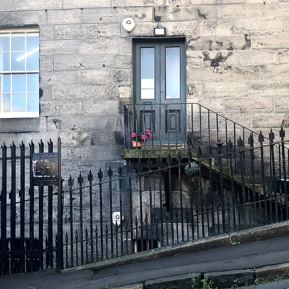 Elevated door with steep steps rising from a steep street.