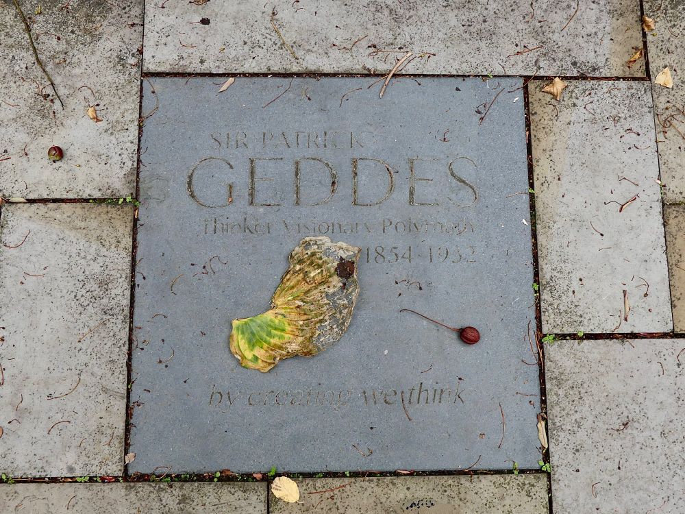 Chance positioning of decayed leaf and fallen nut on memorial plaque for Patrick Geddes, urban planner.