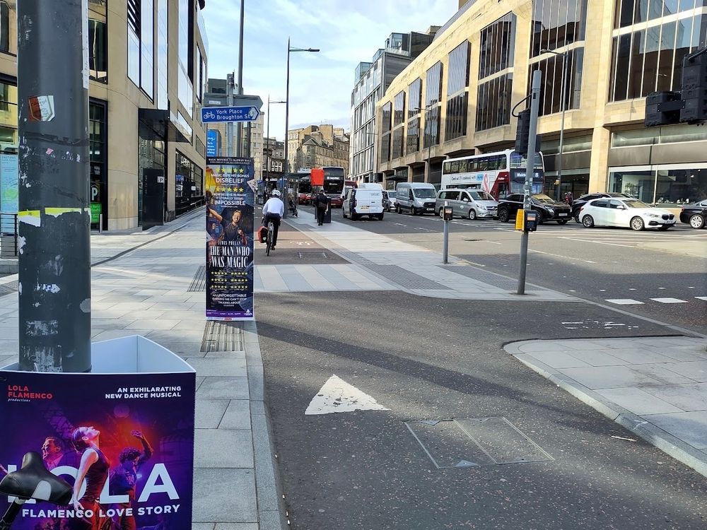 Leith Street, looking south. Pole-mounted advert obscures view of pavement at one end of the pedestrian crossing.
