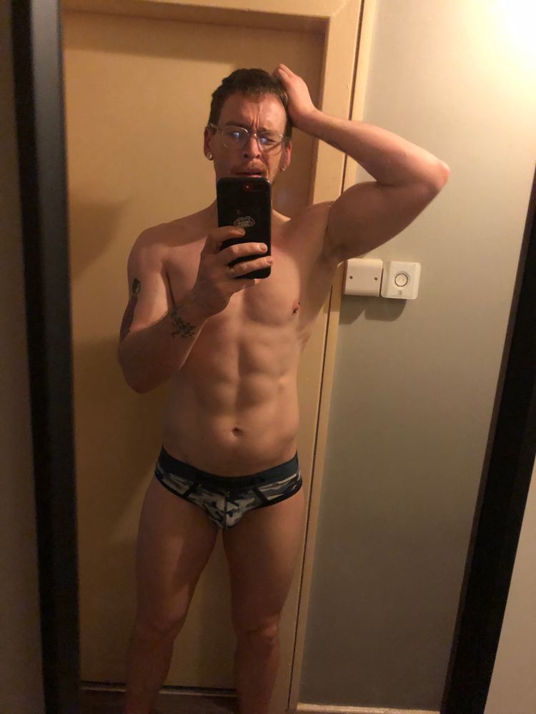 Mirror selfie in weird blue camouflage briefs with a befuddled look on my face 