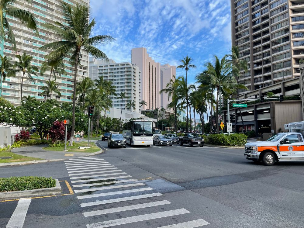 A street scene heading in the direction of Ala Moana in Honolulu.  Nice palm trees and sunny skies.