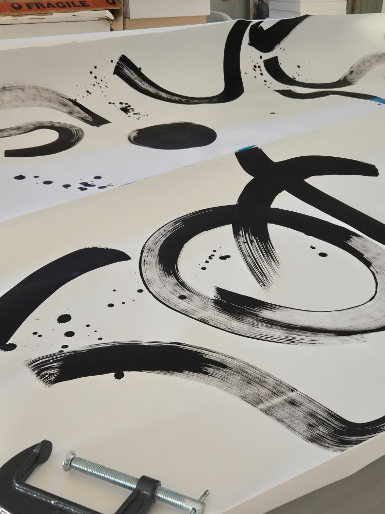Large white piece of paper with random black ink brush strokes.