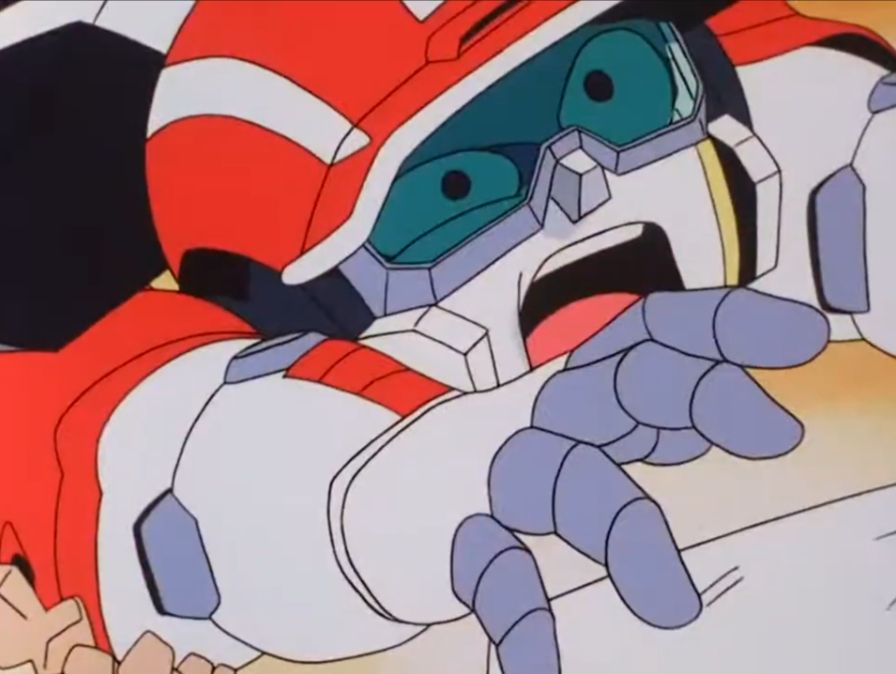 Screenshot from Iron Leaguer episode 6 of Magnum Ace on the ground shouting in pain as Gold Mask stomps on him with his cleats. 