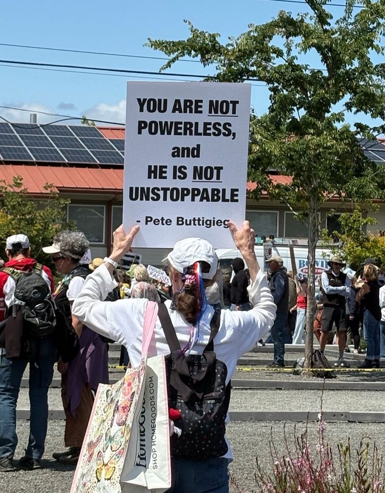 Woman holding sign: You are not powerless. He is not unstoppable 