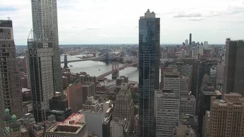 This webcam usually shows the New York city skyline with skyscrapers and the Brooklyn Bridge and the Manhattan Bridge in the center of the view. It's a clear day. It's 79ºF/26ºC.