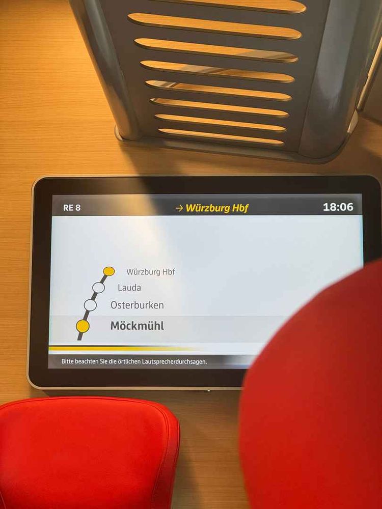Foto des Bildschirms im Zug. Zu sehen ist „RE 8 ➜ Würzburg Hbf“

Die nächsten Halte sind Möckmühl, Osterburken, Lauda und Würzburg Hbf. Die Uhrzeit auf dem Monitor ist 18:06