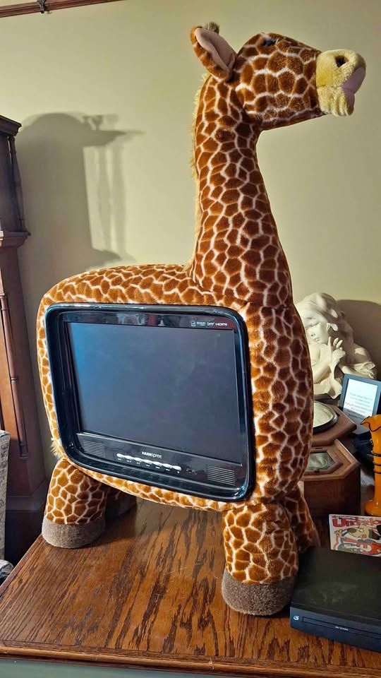 a tv that is encased in a plush giraffe?