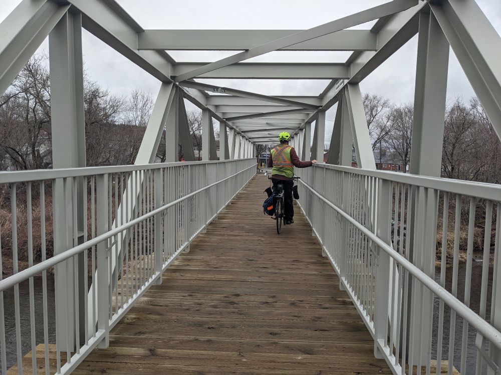 A cyclist stopped on a car free bridge as part of the Sussex Nature Walkway 