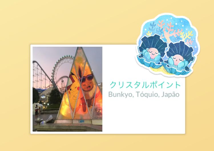 Cartão postal, do lado esquerdo foto de um parque de diversões com uma espécie de pirâmide com desenhos de pokemons, ao lado direito um texto em japonês e a indicação “Bunkyo, Tóquio, Japão”