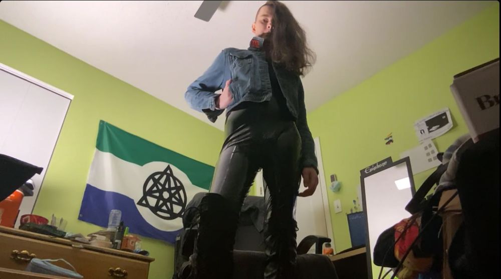 Bug eye view of me in latex, while also wearing my battle jacket and my boots. The non-human unity flag is in the background. Don't worry about the rest of the trash. >_>