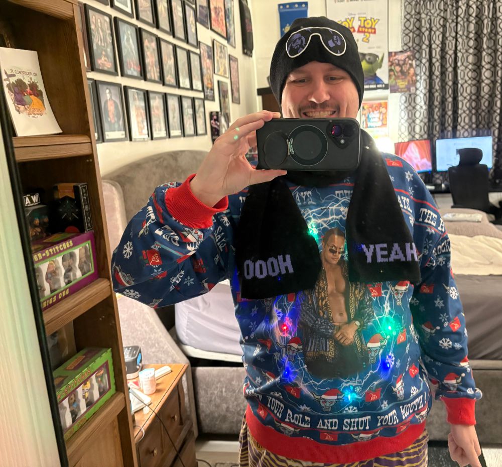 Myself wearing a light up Dwayne Johnson hoodie and a Macho Man beanie and scarf set.