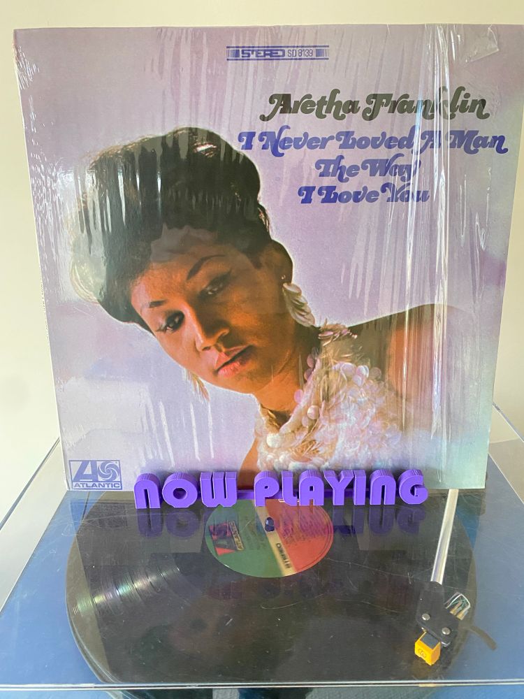 Aretha Franklin’s I Never Loved A Man The Way I Love You cover on record cover “now playing”stand