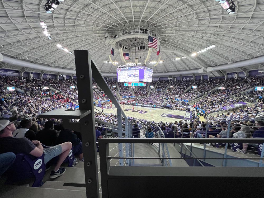 College Basketball Game with a stair rail in the way of half of the court.