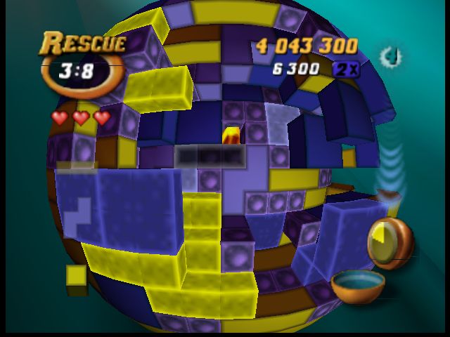 An image of gameplay from Tetrisphere for the Nintendo64. Yellow and purple tetris blocks rendered as a spherical playing field. Current player's score in the upper right corner.