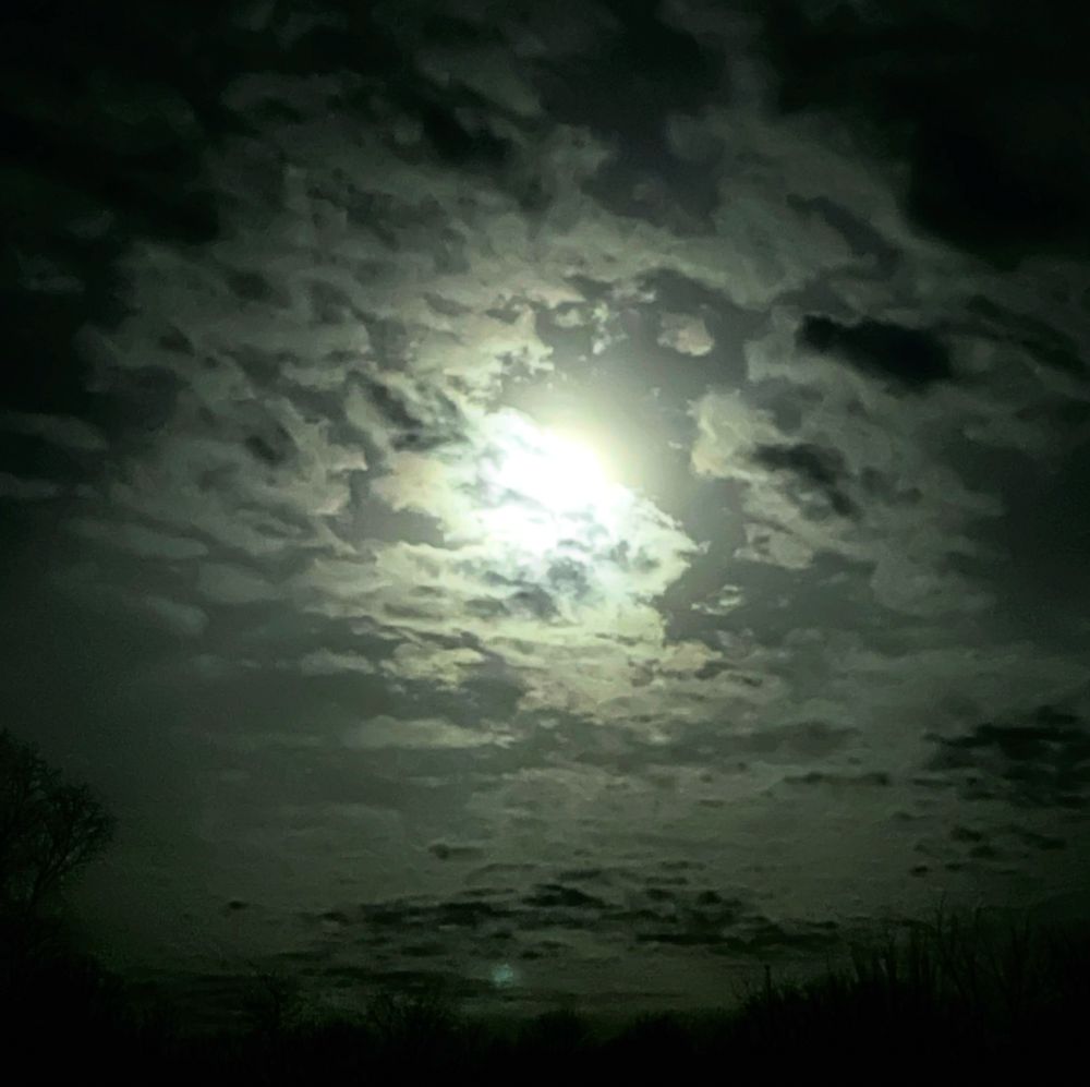 Early morning moon in Minnesota . Bright with layers of clouds.