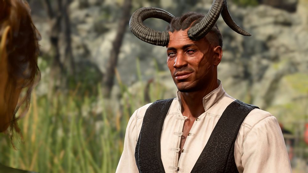 This image is of Wyll as he smiles at Meliahwyl. The screenshot itself is from later in the game, when he has the horns bestowed upon him by Mizora. He is wearing a cream button-up shirt and black waistcoat. 