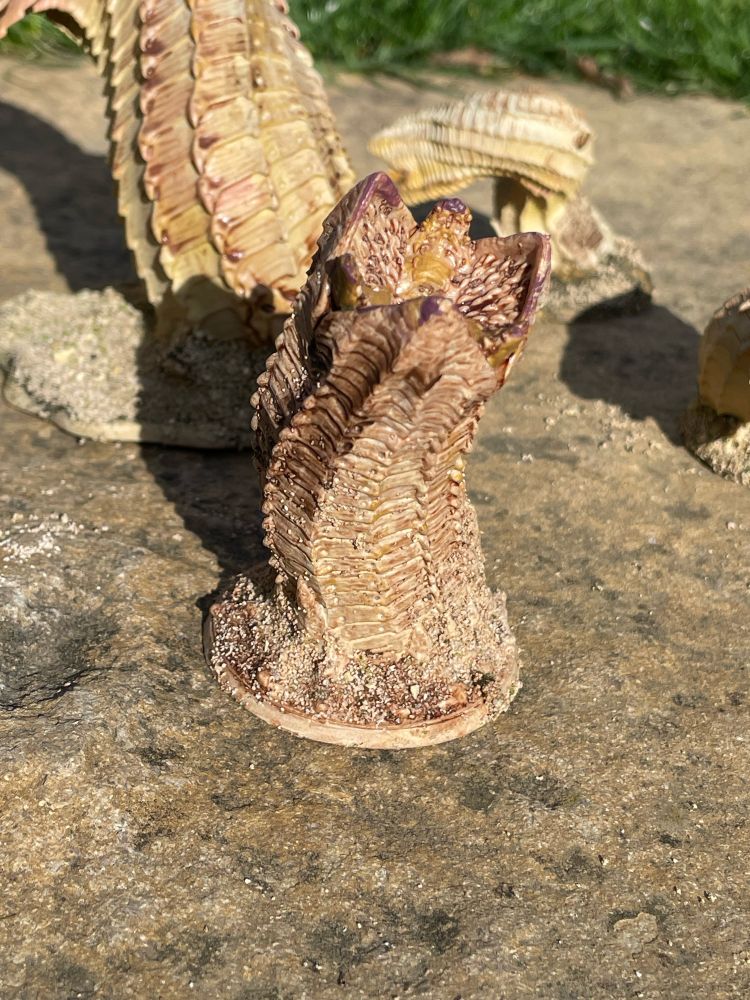 Old Man of the Desert legendary miniature behind large sand worm miniature that has been painted and based from Dune: War for Arrakis