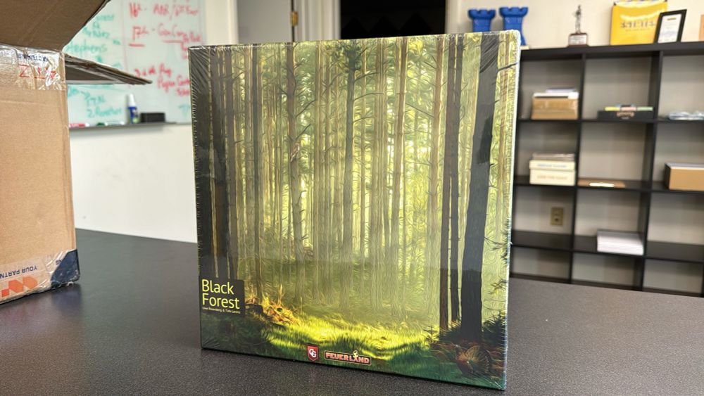 The cover of Black Forest game by Uwe Rosenberg and Tido Lorenz shows tall trees in a painted forest