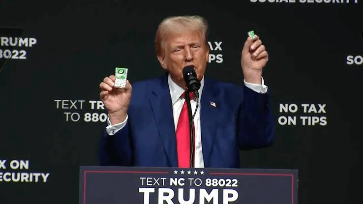 Trump trying to demonstrate inflation with two different sizes of tic tacs. 
In reality he was demonstrating srinkflation but with a small party sized tic tac package. 