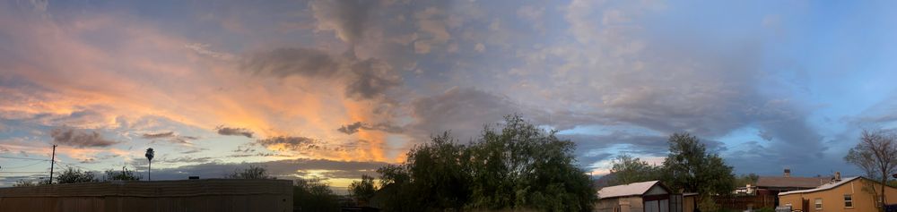a panoramic photo of a sunset juxtaposed with blue sky