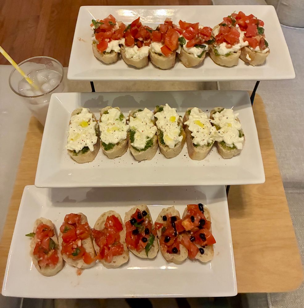 Three rectangular plates of small slices of bread with alternating toppings on them 