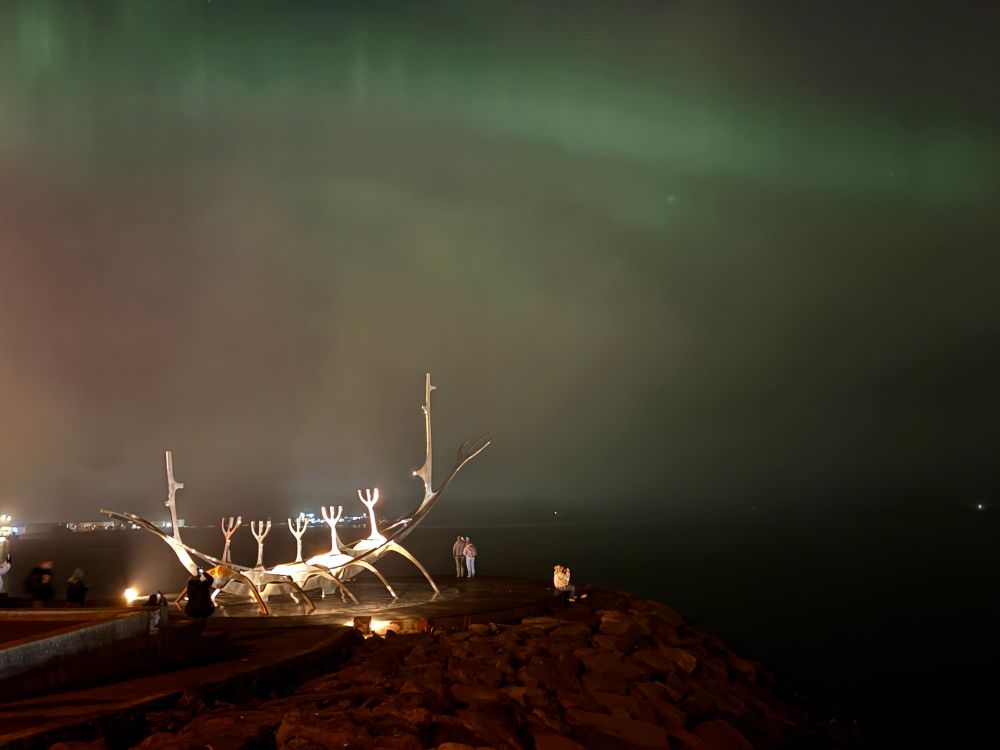 Sky Voyager art sculpture with green aurora borealis behind it 